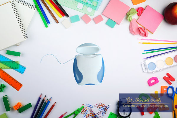 Back-to-school dental checklist with toothbrush, toothpaste, floss, and school supplies for Orange County kids